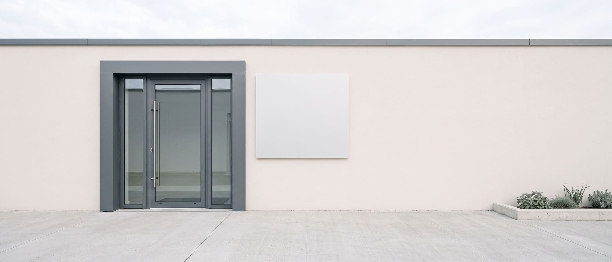 Porte vitrée en aluminium anthracite d’un local professionnel récent, poignée barre en inox, panneau de façade vierge